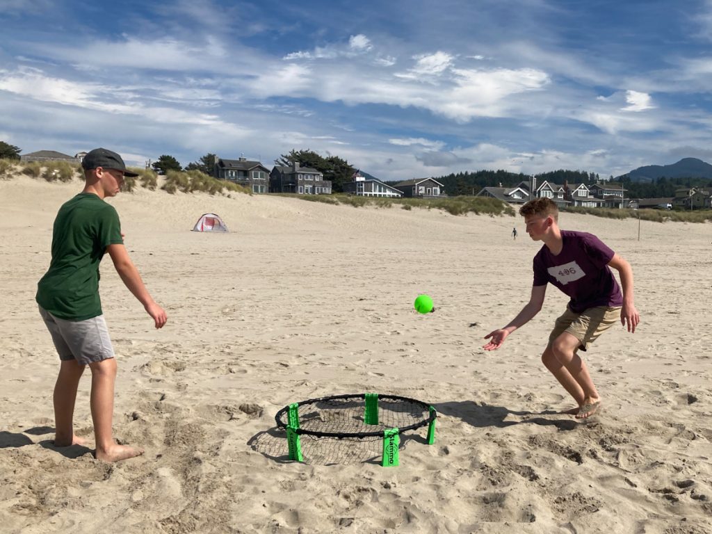 Teen boys playing spike ball at seaside oregon
