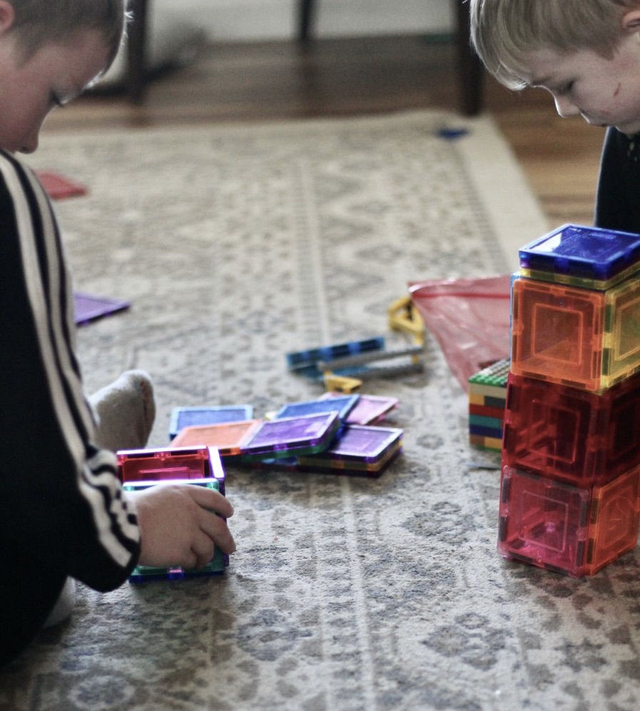 boys playing with magna tiles together as they learn to share and play together